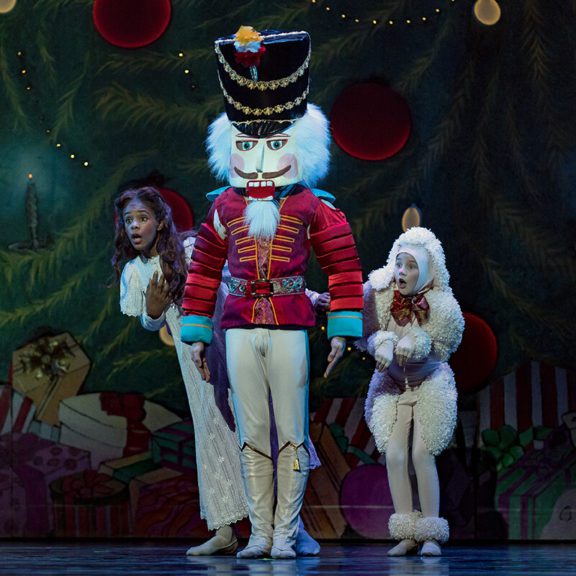 Large Nutcracker On Stage With Two Other People