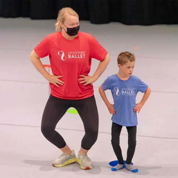 Photo of a woman and a small boy wearing Cincinnati ballet t-shirts posing with their hands on their hips