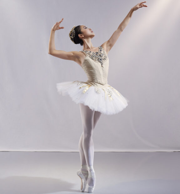 2023-2024 season | Photo of a female ballerina posing in a gold outfit and tutu
